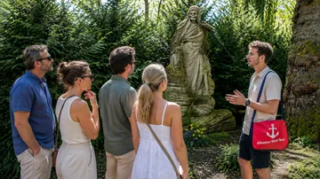 Group of people listening to a guide outdoors.