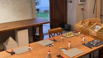 Tisch mit Kunstmaterialien in gemütlichem Raum.