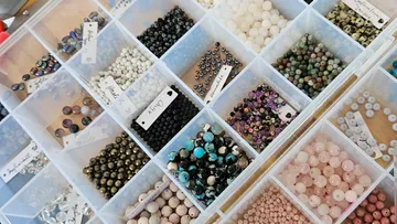 Colorful beads organized in a transparent box.