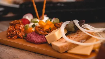 Cheese platter with pretzels and garnishes.