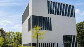 Modern white building with vertical windows.