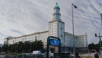 Building with tower near subway entrance.