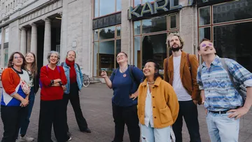 Group smiling outside a Karl Marx building.