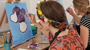 Women painting onions in art class.