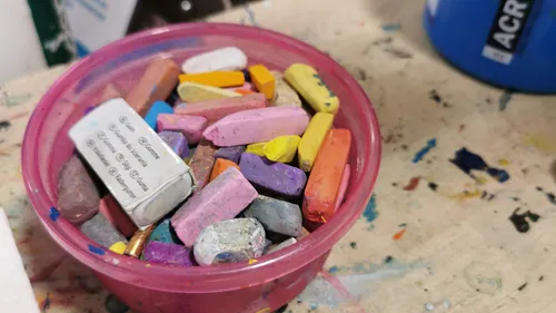 Bunte Kreidestücke in einem Plastikbehälter.