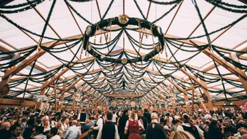 Crowd gathering under decorated festival tent.