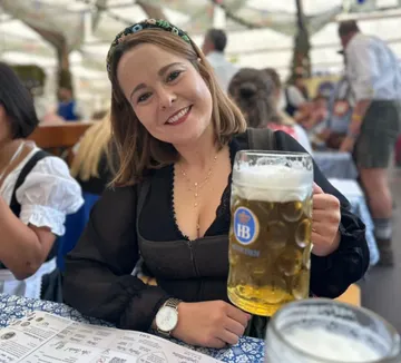 Frau hält Bierkrug, Festumgebung.
