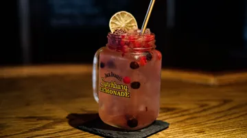 Einmachglas mit Limonade auf Holztisch.