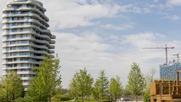 Curved building near trees in urban setting.