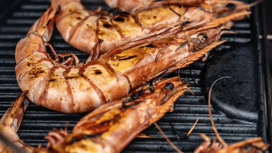 Grill prawns on a hot rack in the kitchen.