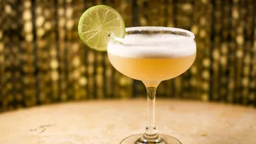 Cocktail mit Limette, auf einem Tisch.