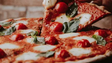 Pizzastück wird vom Ganzen genommen.