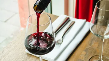 Rotwein wird ins Glas eingeschenkt.