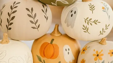 Painted pumpkins arranged in a stack.