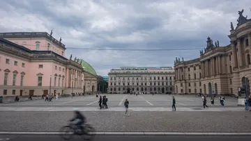Radfahrer fährt an historischem Platz vorbei.