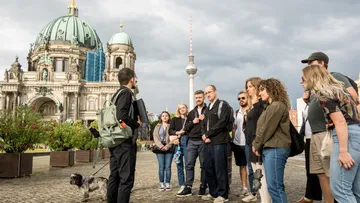 Touristen lauschen Führer nahe Berliner Dom.