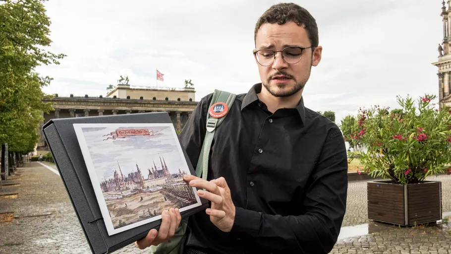 Man displaying a historic print outdoors.
