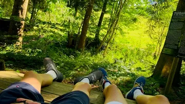 Two people relaxing in a forest.