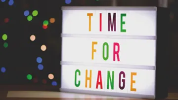 Lightbox displaying 'TIME FOR CHANGE' indoors.
