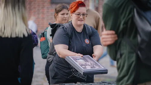 Person hält ein Fotobuch im Freien.