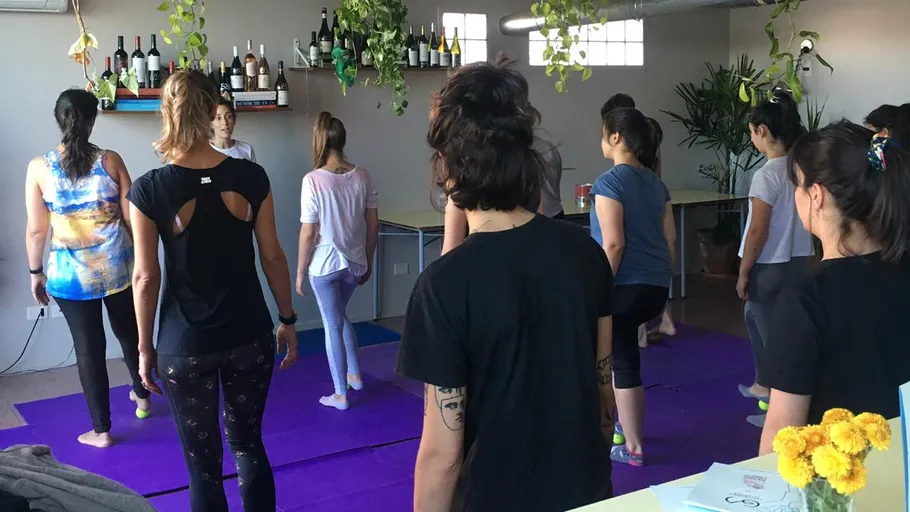 Menschen machen Yoga im Studio mit Pflanzen.