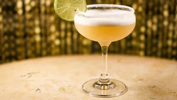 Cocktailglas mit Limette in elegantem Ambiente.