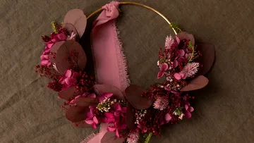 Blumenkranz mit rosa Blumen auf Stoff.