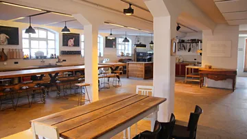 Spacious kitchen with wooden tables, empty.