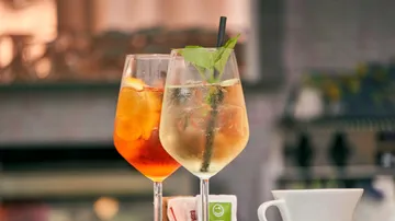 Cocktails in Gläsern auf Außentisch.
