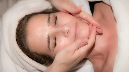Frau bei Gesichtsmassage, entspannte Umgebung.