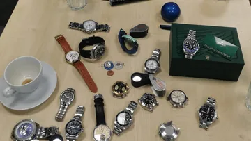 Various watches displayed on wooden table.