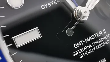 Close-up of Rolex GMT-Master II watch face.