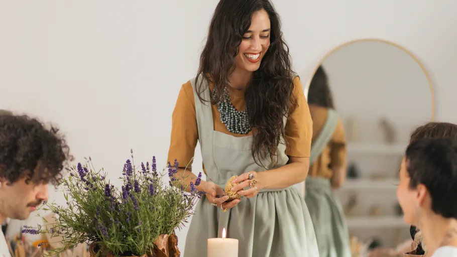Woman lighting candle at cozy gathering.