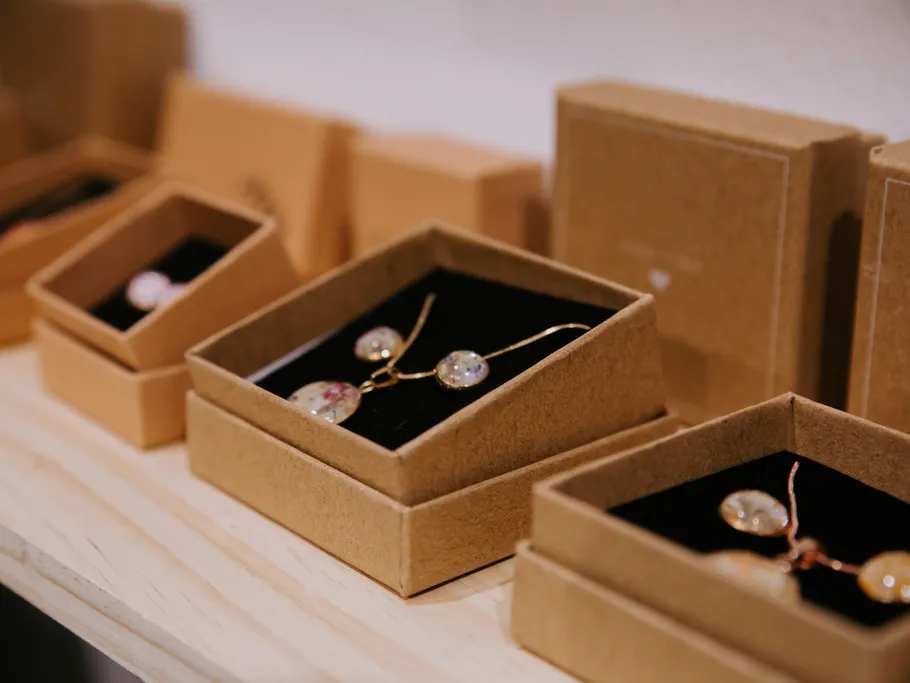 Jewelry boxes with pendant necklaces displayed.