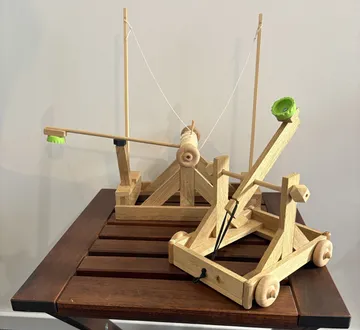 Wooden catapults displayed on a wooden table.
