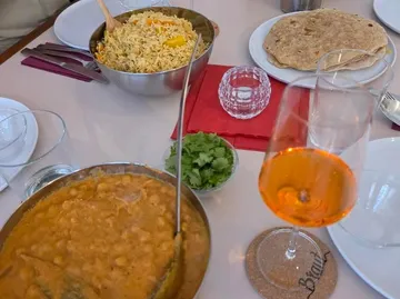 Indisches Essen auf Tisch mit Getränk.