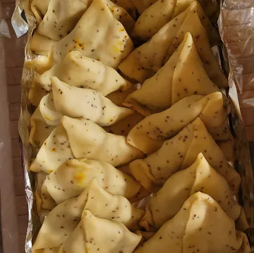 Gefüllte Teigtaschen auf einem Tablett.
