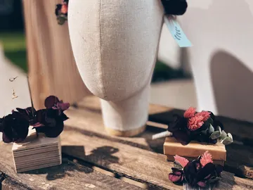 Eine Kopfhaube mit Blumenarrangements auf rustikalem Holz.