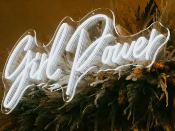Neon light with the words “Girl Power” in front of plants.
