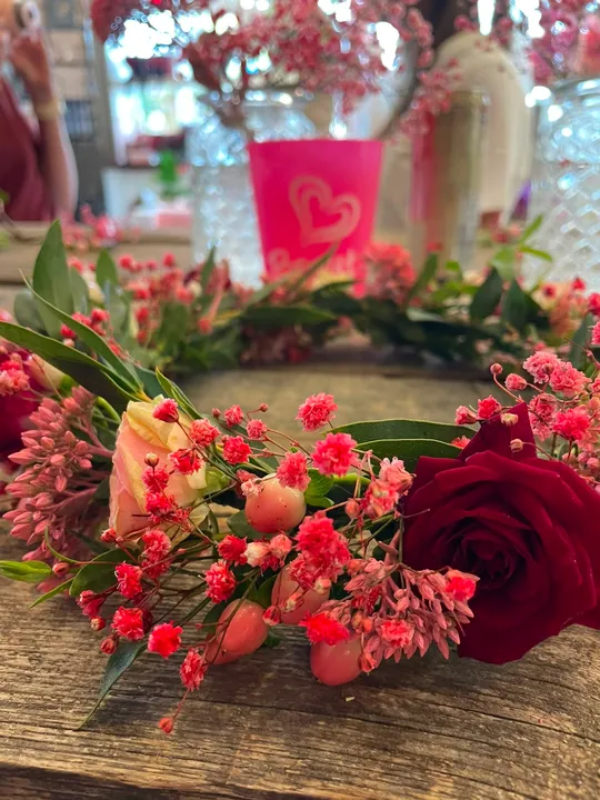 Floral crown lies on wooden table.