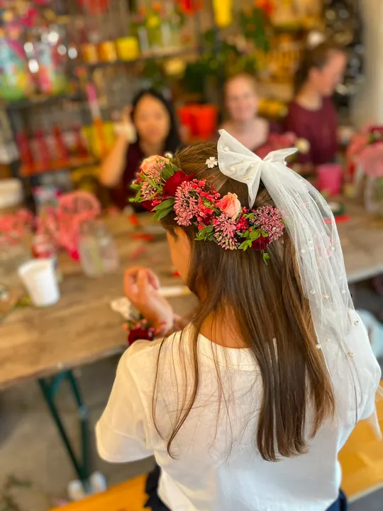 Woman with flower crown at crafting table.