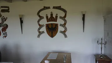 Wappen an der Wand in einem Raum.