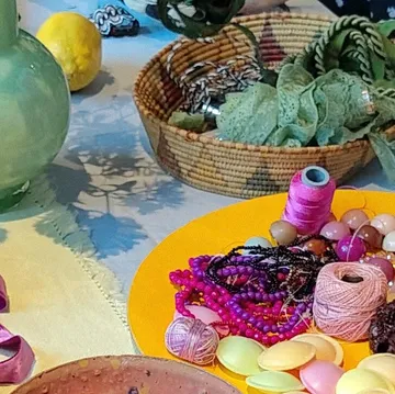Hands organizing crafting materials on table.