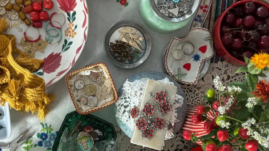 Craft supplies and cherries on colorful table.