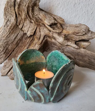 Kerzenhalter mit Teelicht auf Tisch.