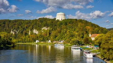 Hilltop rotunda above river with boats.