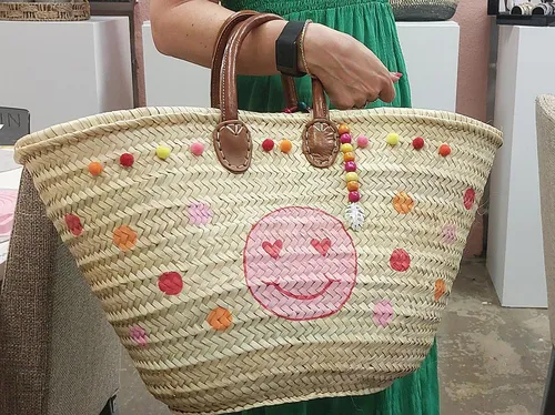 Woven bag with colorful smiley design.
