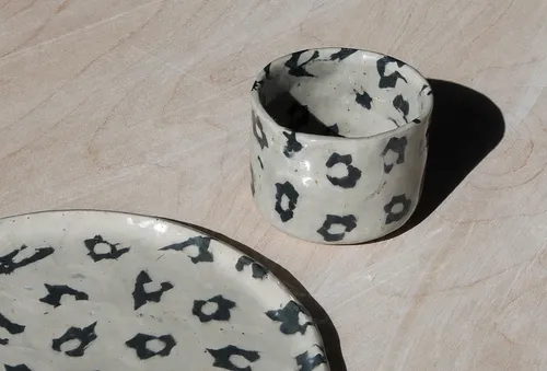 Ceramic cup and plate on wooden surface.