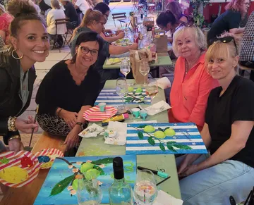 Frauen malen bei einem zwanglosen Essen.