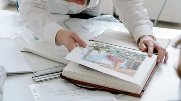 Person betrachtet Kunst in offenem Buch.